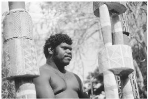 An Aborigine from the Tiwi tribe in Bathurst, New South Wales, Australia, stands beside painted funeral totems. Phases of funerary rites are often explicitly devoted to symbolic acts that send ancestral spirits back to their places of origin where they assume responsibility for the wellbeing of the world they have left behind. CHARLES AND JOSETTE LENARS/CORBIS