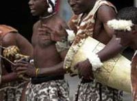 man with feather in hair holding a drum